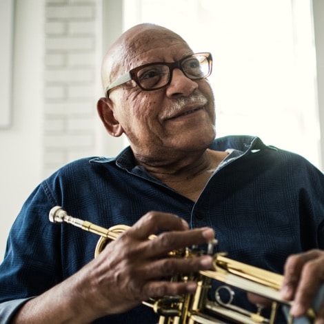 Man holding a trumpet smiling