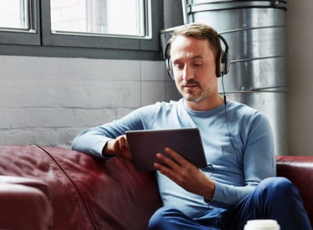 Man looking at ipad with headphones on